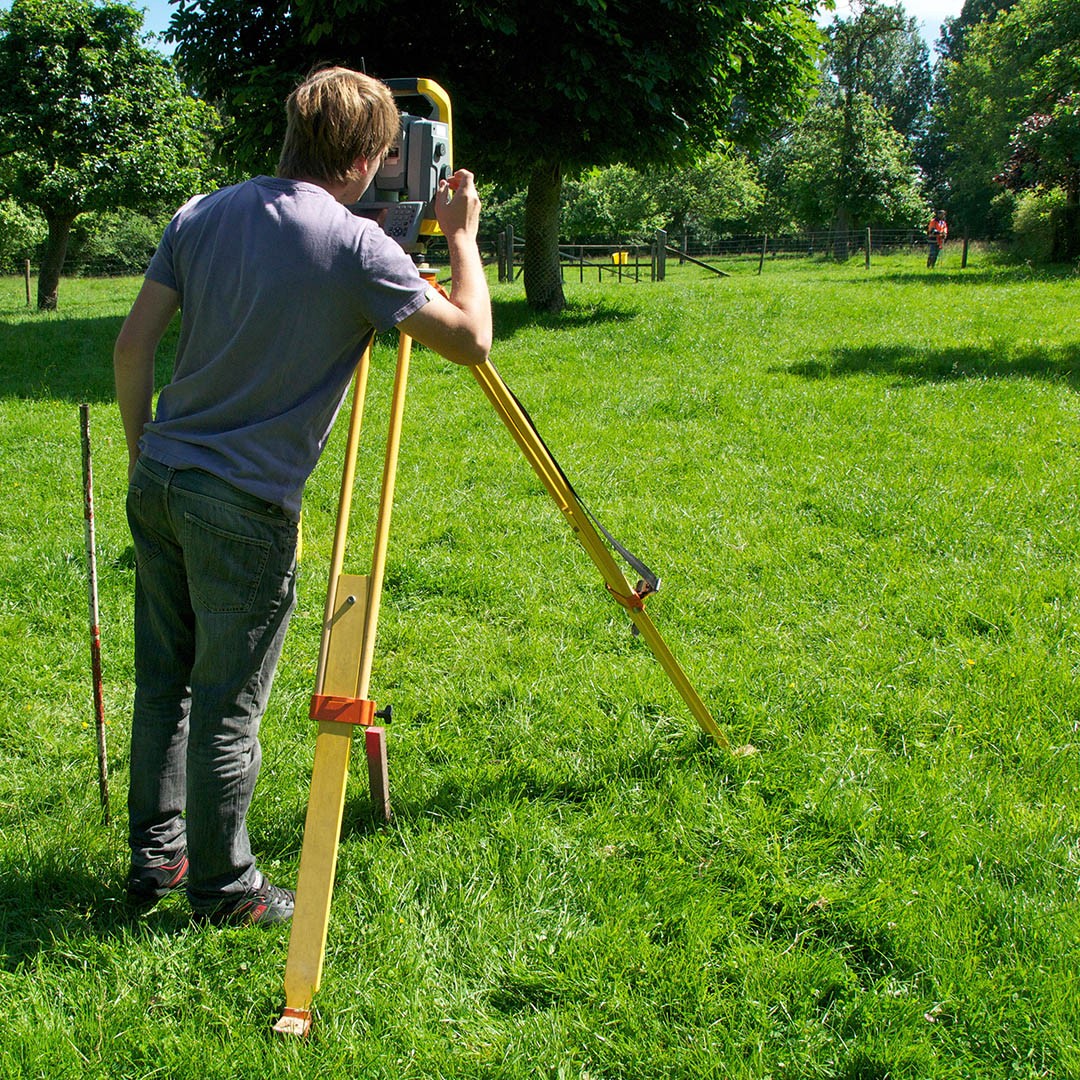 Géomètre en train de borner un terrain